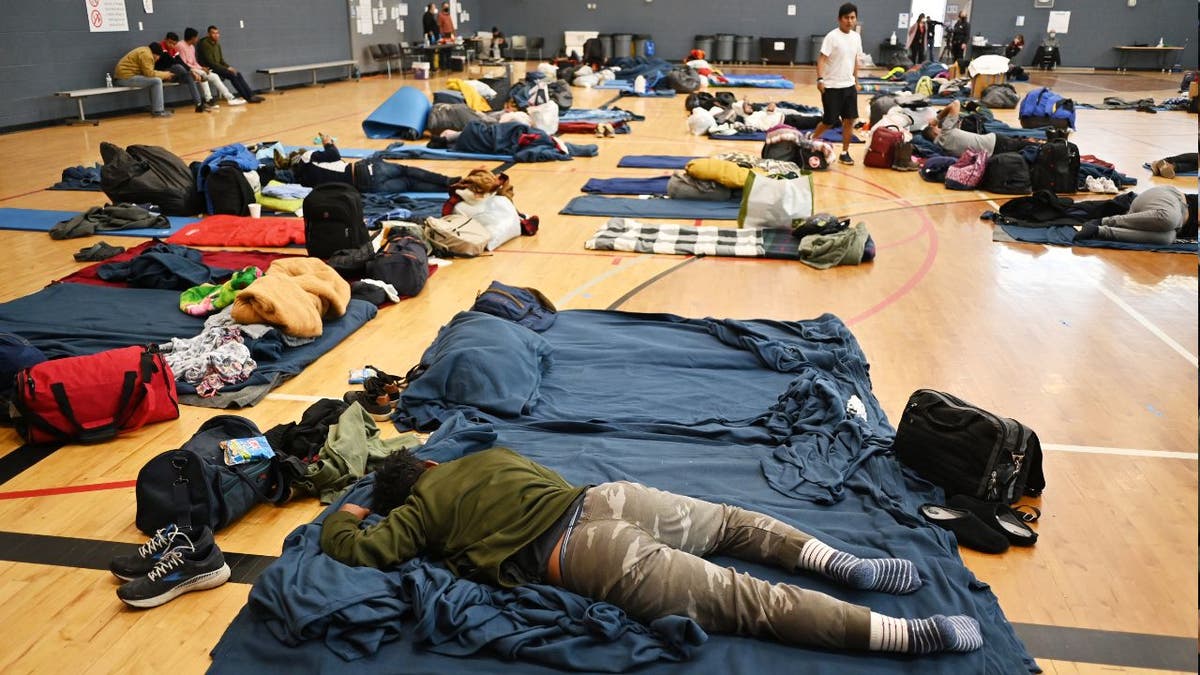 A migrant lie on the sleeping pad at a makeshift shelter in Denver, Colorado