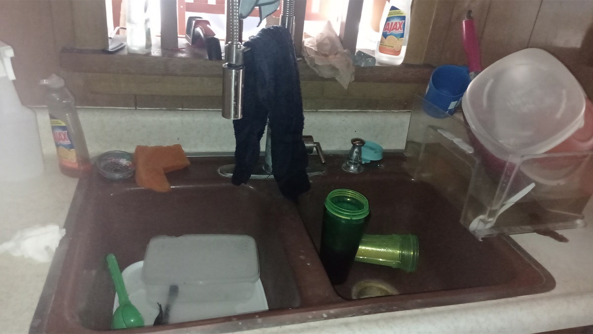 Dishes left in the sink by squatter in Yudith Matthews and Abram Mendez's home.