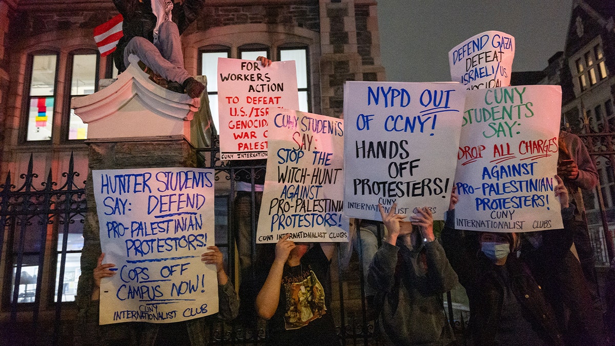 Pro-Palestinian protesters hold signs at CCNY