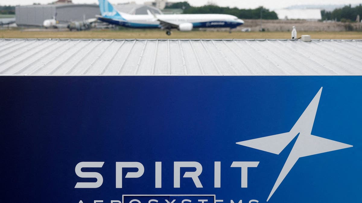 Boeing 737 MAX jet lands over a Spirit AeroSystems logo in Paris