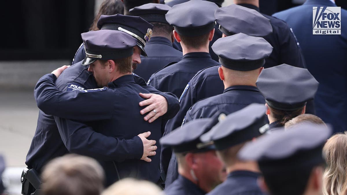 Police hug each other
