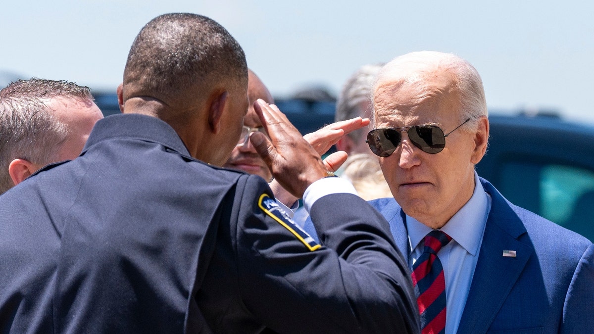 President Joe Biden salutes Charlotte-Mecklenburg Police Department Chief Johnny Jennings, as he arrives on Air Force One at Charlotte Douglas International Airport, Thursday, May 2, 2024, in Charlotte, N.C.