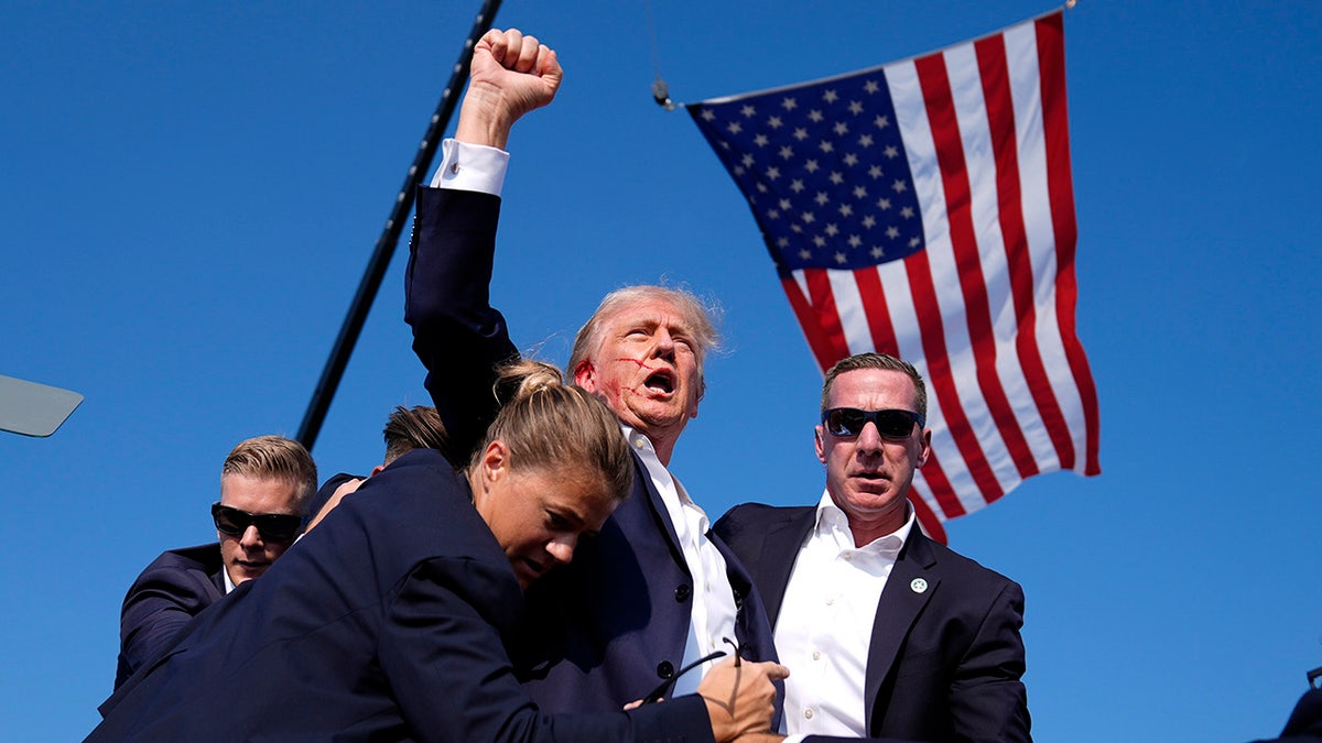 Donald Trump is surround by U.S. Secret Service agents at a campaign rally,