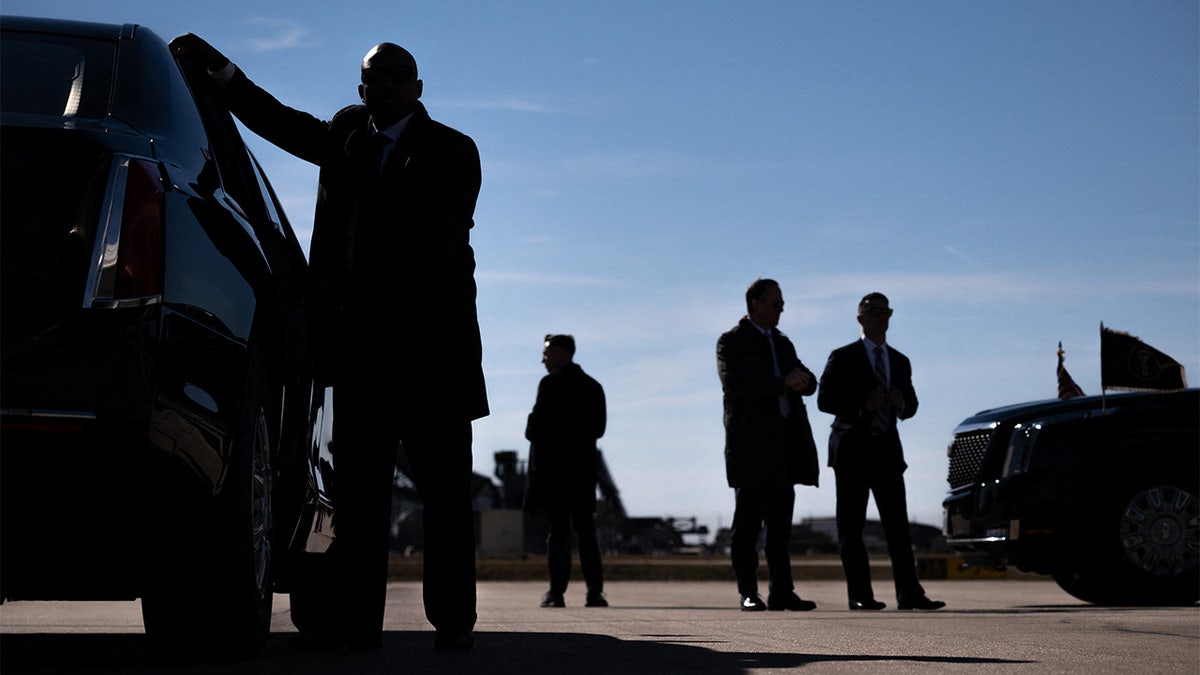Secret Service agents stand by the presidential limousine as President Biden disembarks from Air Force One upon arrival at Raleigh-Durham International Airport in Morrisville, N.C., in January.