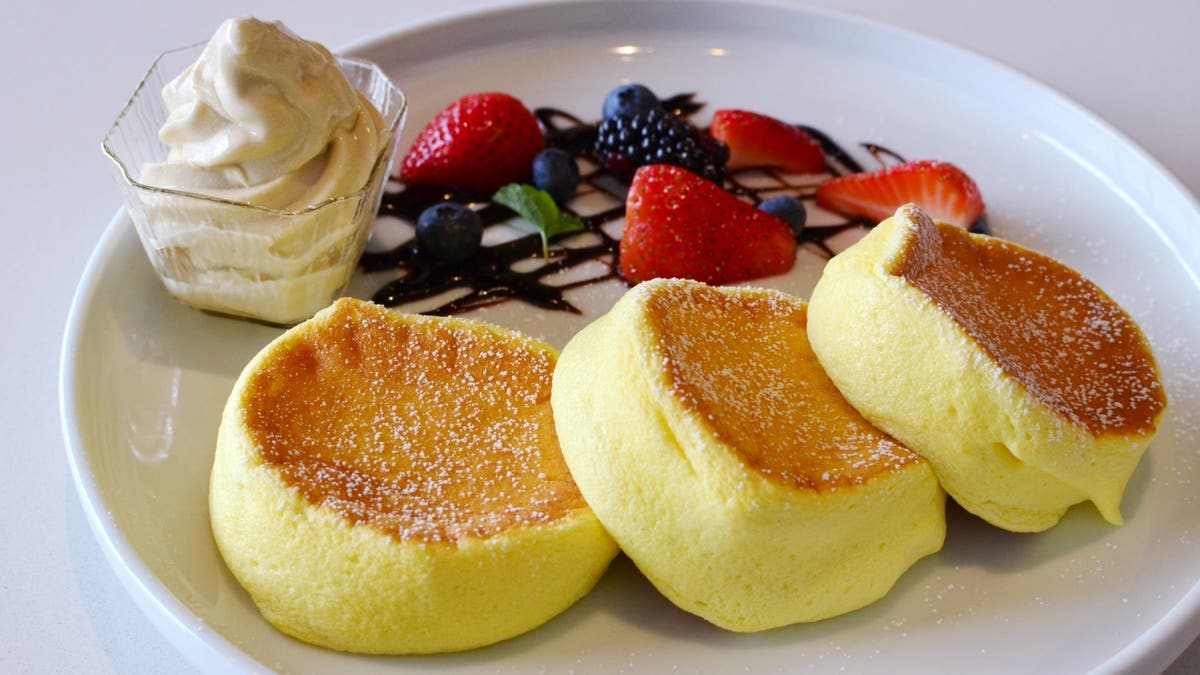 Japanese souffle pancakes are served with ice cream and mixed berries.