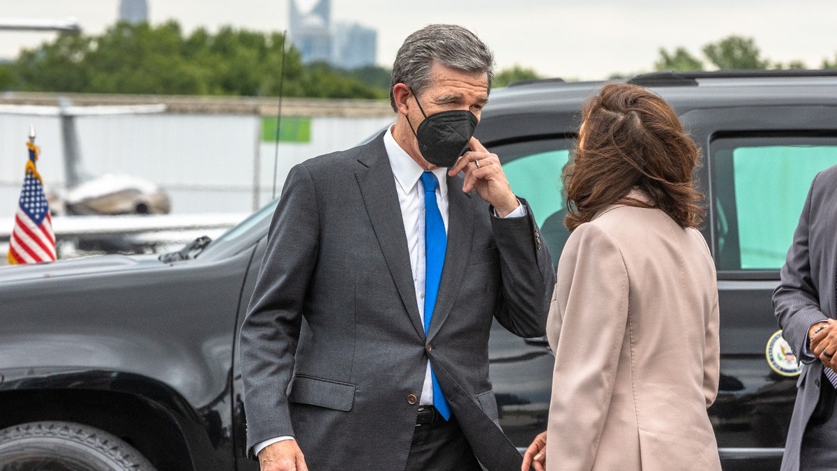 US Vice President Kamala Harris is greeted by Roy Cooper