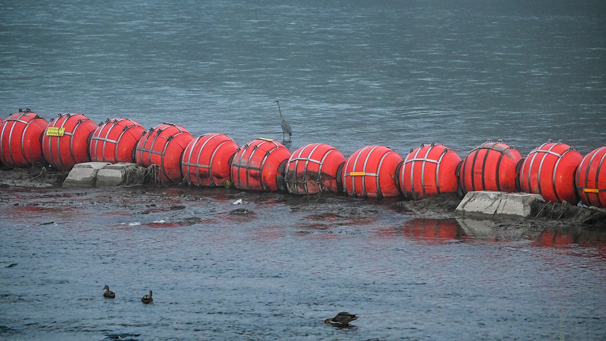 floating barrier is deployed in the middle of the Rio Grande