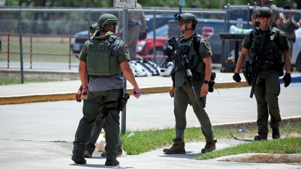 Law enforcement personnel stand outside Robb Elementary School following a shooting, Tuesday, May 24, 2022, in Uvalde, Texas.