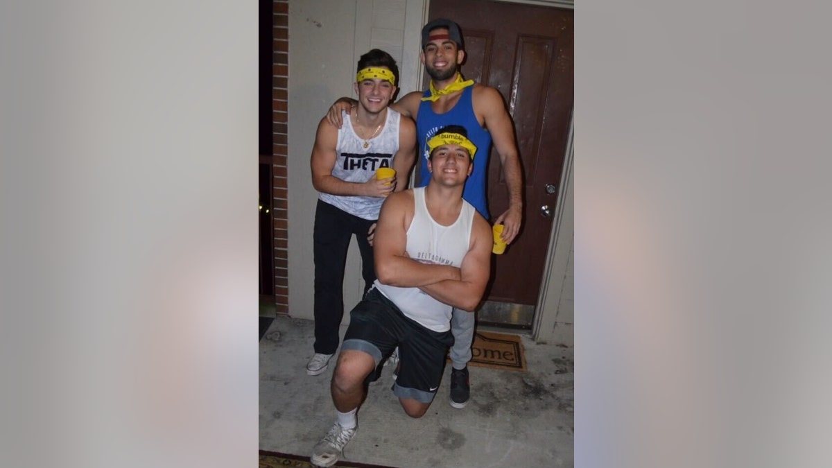 Nicholas Mauricio poses with his fraternity "big brother" and "grand big brother" during a pledge night in 2018.