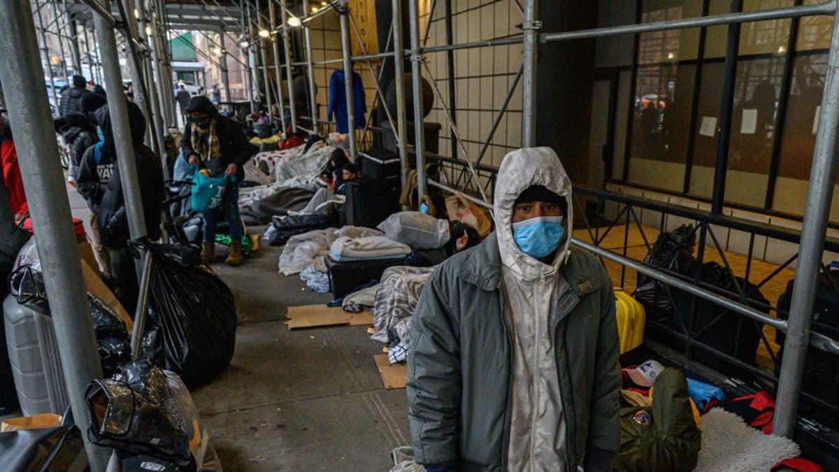 TOPSHOT - Migrants camp outside a hotel where they had previously been housed, as they resist efforts by the city to relocate them to a Brooklyn facility for asylum seekers, in the Hells Kitchen neighborhood of New York on January 31, 2023. (Photo by Ed JONES / AFP) (Photo by ED JONES/AFP via Getty Images)