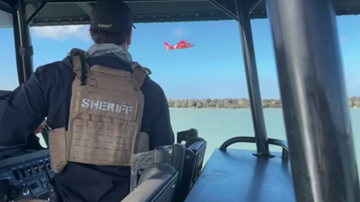 Sheriff's deputy on water looking at helicopter