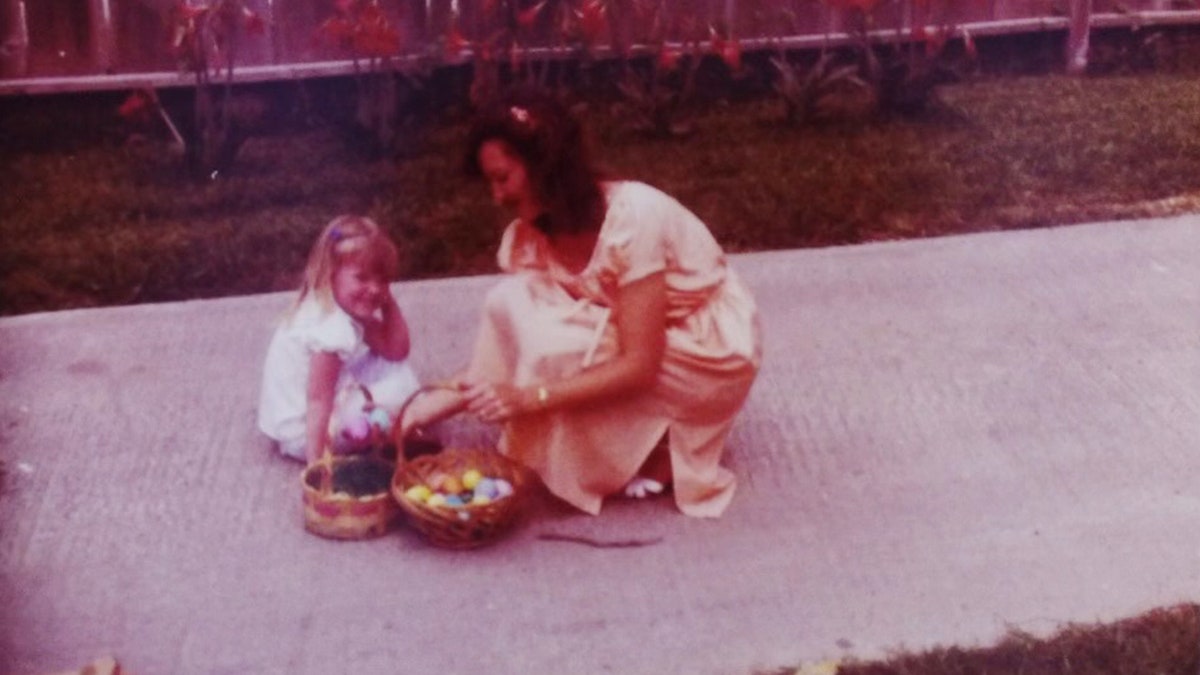 Wanda Holloway kneeling down next to her daughter Shanna next to two Easter baskets.