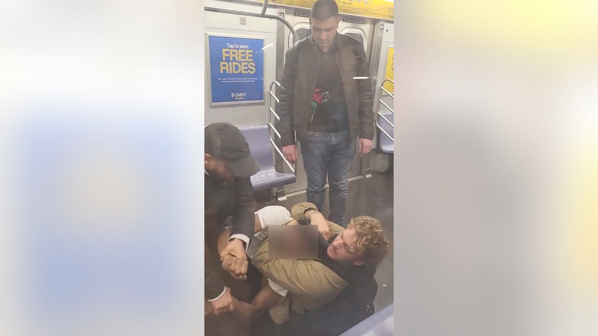 daniel penny holds jordan neely in a chokehold on a subway car floor