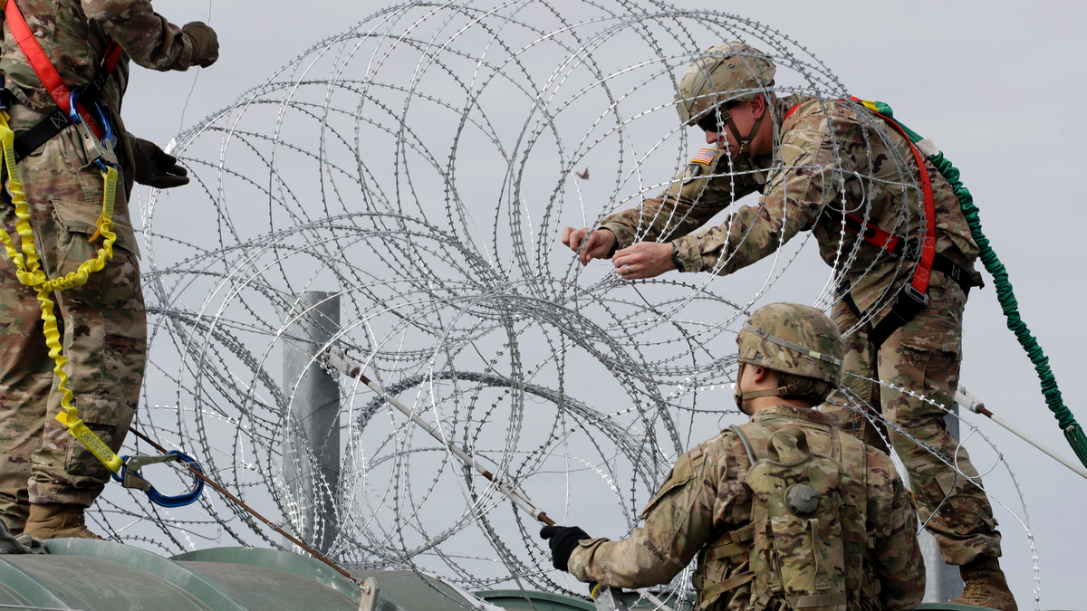 Members of the U.S.military place razor wire along the U.S.-Mexico border on the McAllen-Hidalgo International Bridge, Friday, Nov. 2, 2018, in McAllen, Texas. (AP Photo/Eric Gay)