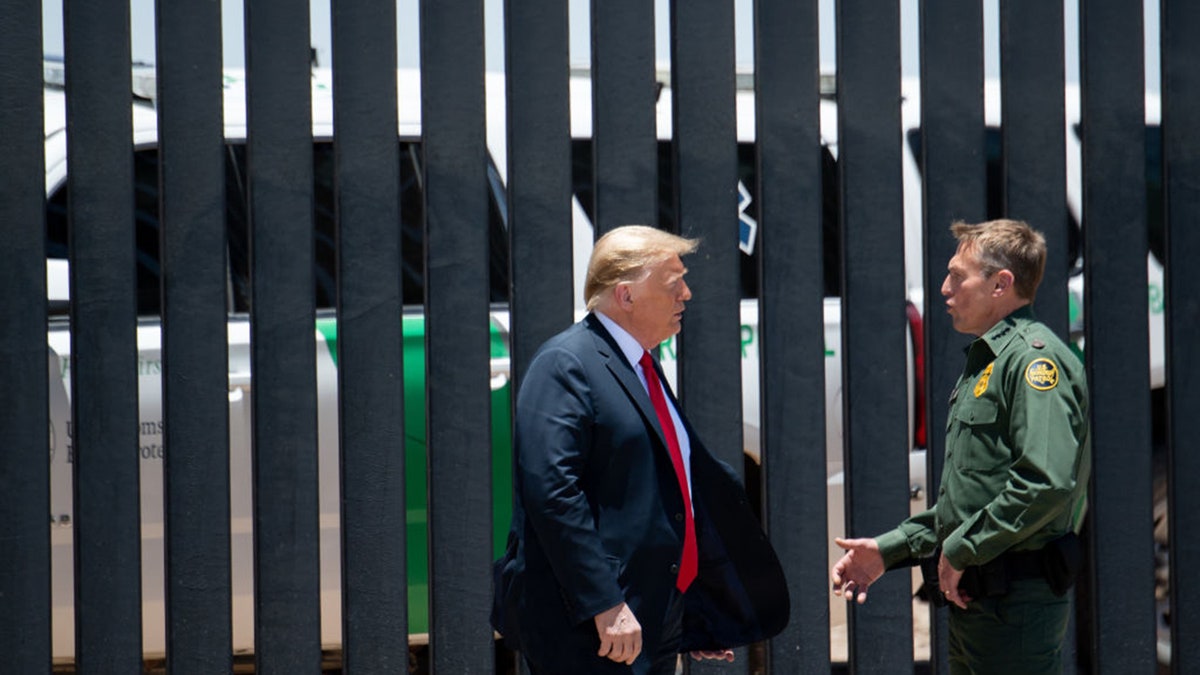 Then-President Trump, left, speaks with U.S. Border Patrol Chief Rodney Scott as they participate in a ceremony commemorating the 200th mile of border wall at the international border with Mexico in San Luis, Arizona, on June 23, 2020.