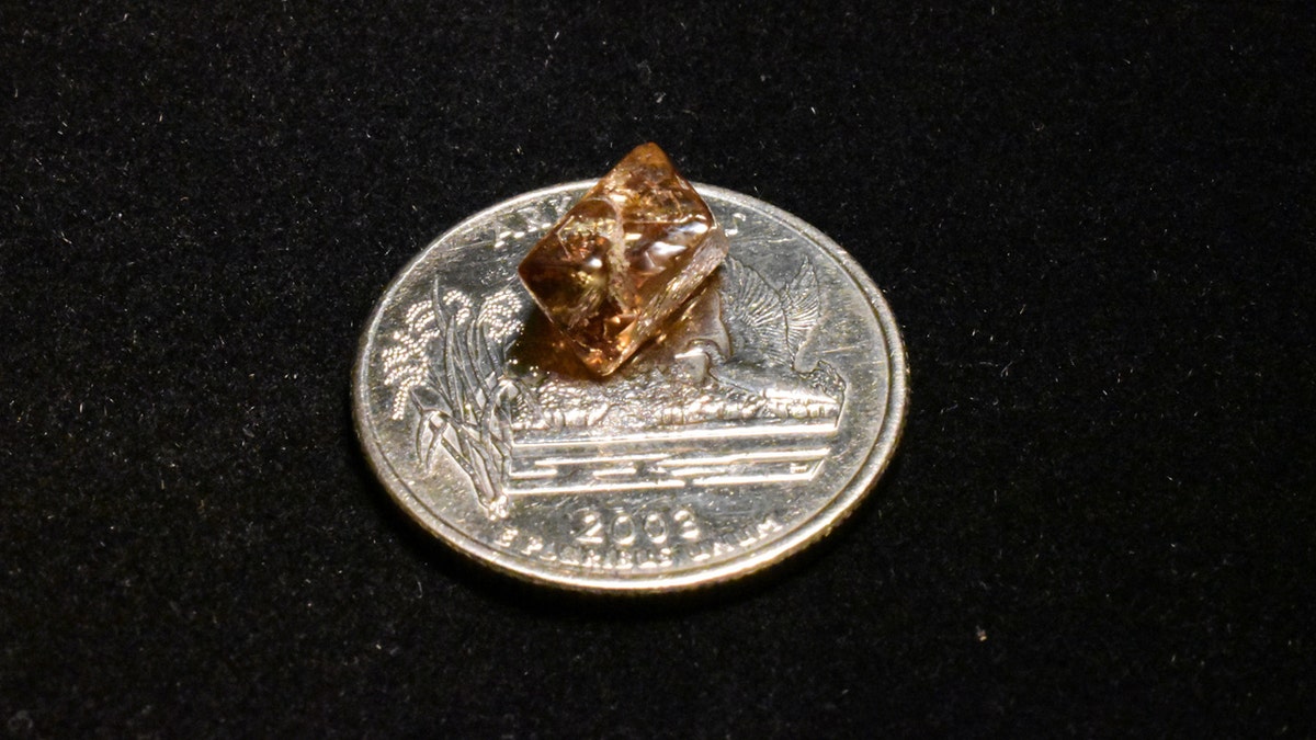 3.81-carat diamond on top of quarter 
