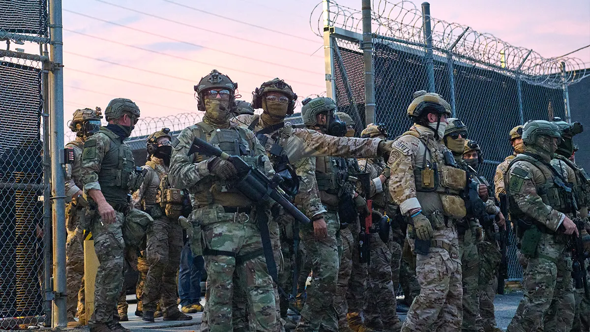 Federal agents confront protesters outside the ICE Detention Center